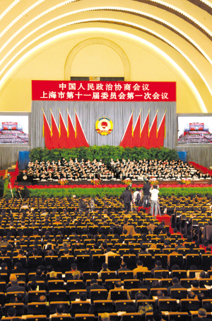 巨大的人民政协会徽悬挂在大会主席台正中,十面红旗分列两旁.