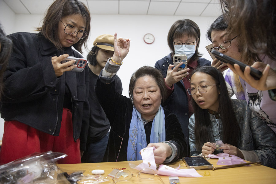 在市群艺馆总校Q版娃娃制作课程上,老师教学员穿针。.jpeg 在市群艺馆总校Q版娃娃制作课程上,老师教学员穿针。.jpeg